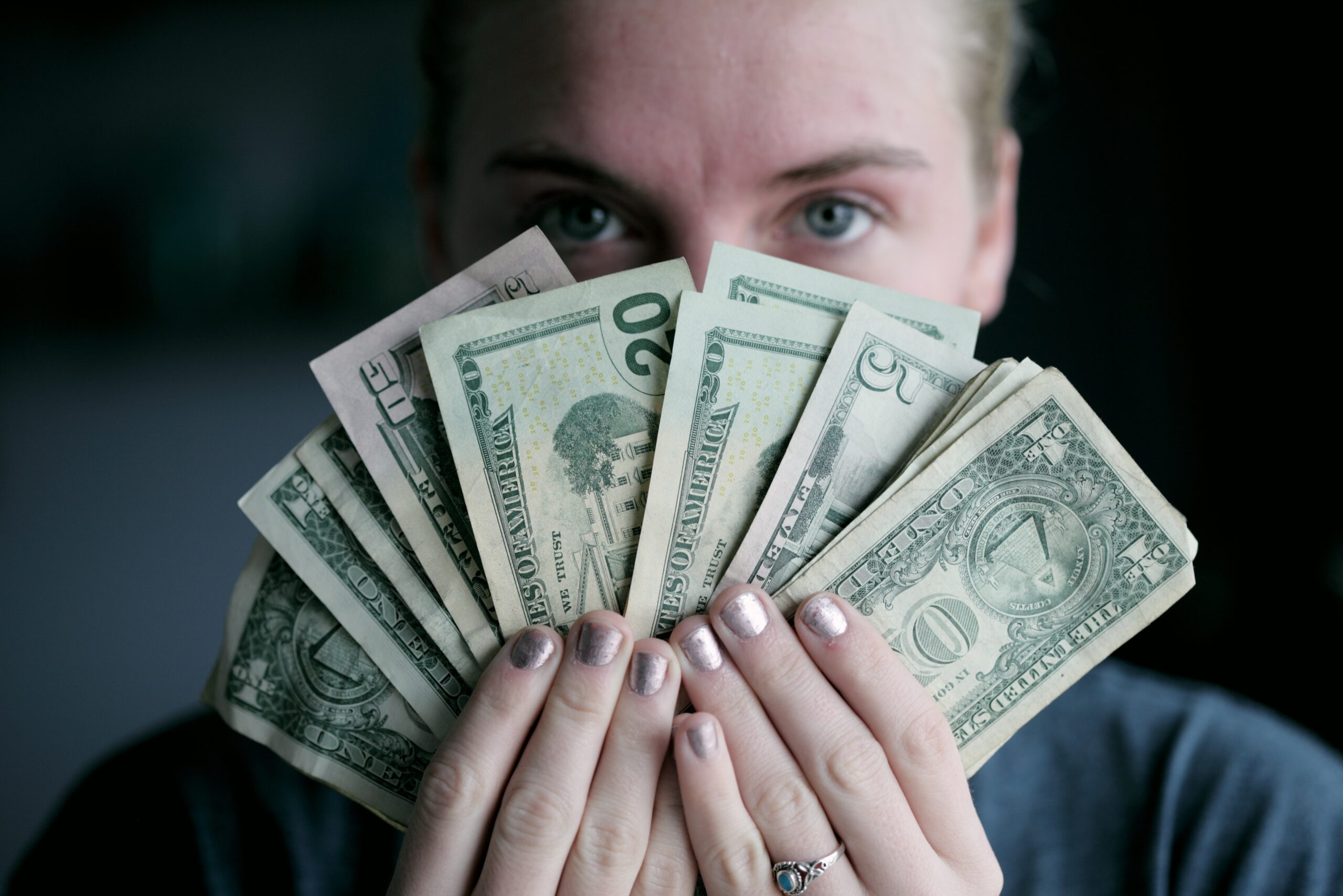 woman holding money in dollar notes